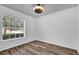 Well-lit bedroom featuring wood floors, a ceiling fan, and a large window at 2988 Santa Maria Ave, Clermont, FL 34715