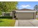 Charming single-story home with a well-manicured lawn, a two car garage, and lush green shrubbery at 2988 Santa Maria Ave, Clermont, FL 34715