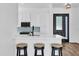 Modern kitchen with white countertops, stainless steel appliances, and three bar stools for seating at 2988 Santa Maria Ave, Clermont, FL 34715