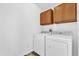 Laundry room complete with washer, dryer, and overhead cabinets at 2988 Santa Maria Ave, Clermont, FL 34715