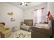 Charming bedroom with playful decor, including a crib and a cozy armchair at 3193 Hill Point St, Minneola, FL 34715