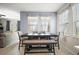 Open dining area with large windows providing natural light and a modern table and bench set with seating for six at 3193 Hill Point St, Minneola, FL 34715