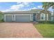 Beautiful single-Gathering home with a three-car garage and brick-paved driveway and walkway to the front door at 3193 Hill Point St, Minneola, FL 34715
