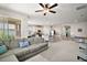 Bright open-concept living room featuring plush seating, an open floor plan, and natural light from sliding glass doors at 3193 Hill Point St, Minneola, FL 34715