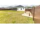 Picture of a backyard with green grass, a dark wood fence, and two wooden planter boxes at 3273 Dzuro Dr, Oxford, FL 34484