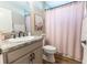 Bathroom featuring a modern vanity with grey countertops, a white sink, and a pink shower curtain at 3273 Dzuro Dr, Oxford, FL 34484