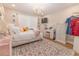 Bright bedroom with a bed, dresser, vanity, and soft rug, illuminated by a chandelier at 3273 Dzuro Dr, Oxford, FL 34484