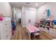 A bedroom with a play table and plenty of toy storage, with wood flooring and neutral walls at 3273 Dzuro Dr, Oxford, FL 34484