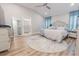 Bedroom with vaulted ceiling, wood flooring, neutral decor, and a view to the attached bathroom at 3273 Dzuro Dr, Oxford, FL 34484
