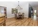 Elegant dining room with chandelier, seating for four, and beautiful wood-look flooring at 3273 Dzuro Dr, Oxford, FL 34484