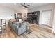 Open concept living room with wood-look flooring, entertainment center, and comfortable seating at 3273 Dzuro Dr, Oxford, FL 34484