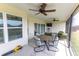 Screened patio with multiple ceiling fans, comfortable seating, and an outdoor dining table at 3273 Dzuro Dr, Oxford, FL 34484