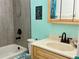 Beautiful bathroom featuring tiled shower with built-in niche, wood vanity, and turtle decor at 36337 Terra Ct, Grand Island, FL 32735