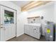 Functional laundry area with a washer, dryer, and water heater, plus outdoor access at 36337 Terra Ct, Grand Island, FL 32735