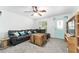 Inviting living room featuring a plush gray sofa, rustic wood accents, and a ceiling fan at 36337 Terra Ct, Grand Island, FL 32735