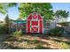 Adorable red and white shed in a private backyard with plants adding charm at 36337 Terra Ct, Grand Island, FL 32735
