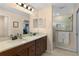 Modern bathroom featuring double sinks, a walk-in shower with glass doors, and ample counter space at 3641 Arlington Ridge Blvd, Leesburg, FL 34748