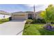 Charming single-story home featuring a well-maintained lawn, beige exterior, and attached two car garage at 3641 Arlington Ridge Blvd, Leesburg, FL 34748