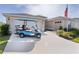 Image of a stylish blue ICON golf cart and the home's two-car and single car garages at 3641 Arlington Ridge Blvd, Leesburg, FL 34748