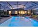 Inviting screened-in pool area with lounge chairs, umbrellas, and open access to the home, enhancing indoor-outdoor living at 3641 Arlington Ridge Blvd, Leesburg, FL 34748