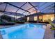 Relaxing screened-in pool with chaise lounges, umbrellas, and seamless access to the home, blurring the lines between indoor and outdoor spaces at 3641 Arlington Ridge Blvd, Leesburg, FL 34748