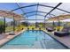 Sparkling screened-in pool surrounded by lounge chairs and umbrellas, offering a serene outdoor retreat for relaxation and recreation at 3641 Arlington Ridge Blvd, Leesburg, FL 34748