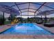Sparkling screened-in pool with lounge chairs and ambient lighting, providing a relaxing oasis for recreation and enjoyment at 3641 Arlington Ridge Blvd, Leesburg, FL 34748