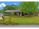 Landscaped front yard with colorful flowers, manicured lawn, and a charming seating area near the entrance at 375 N Boyd St, Winter Garden, FL 34787