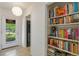 Bright hallway featuring terrazzo flooring and a view of a bookcase; kitchen visible through a doorway at 375 N Boyd St, Winter Garden, FL 34787