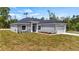 Charming single-story home featuring stone accents, a gray color palette and a well-manicured lawn at 40700 E Ninth Ave, Umatilla, FL 32784