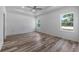Bright main bedroom with tray ceiling, ceiling fan and wood-look flooring, plus large windows at 40700 E Ninth Ave, Umatilla, FL 32784