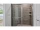 Shower with glass enclosure and light gray tiled walls and shower niche at 40700 E Ninth Ave, Umatilla, FL 32784
