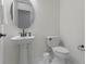 Bathroom featuring a pedestal sink, toilet, and minimalist decor at 4131 Sunset Preserve Blvd, Orlando, FL 32820