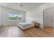 Bright bedroom with wood floors, ceiling fan, and a cozy bed near a large window with outdoor views at 4131 Sunset Preserve Blvd, Orlando, FL 32820