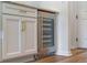 Kitchen offers a stainless steel beverage cooler and white shaker cabinets with gold hardware at 4131 Sunset Preserve Blvd, Orlando, FL 32820