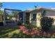 Landscaped backyard featuring a screened-in patio, well-maintained lawn, and lush greenery, ideal for outdoor enjoyment at 5008 Sawgrass Lake Cir, Leesburg, FL 34748