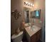 Bathroom featuring a vanity with sink, mirror with lights, toilet, and decorative wall art, offering functionality at 5008 Sawgrass Lake Cir, Leesburg, FL 34748