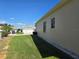 Beige exterior home with a green lawn, and a detached garage in the distance, showcasing the property's layout at 5008 Sawgrass Lake Cir, Leesburg, FL 34748