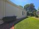 Beige exterior home featuring a well-maintained lawn, and a manicured landscape bed at 5008 Sawgrass Lake Cir, Leesburg, FL 34748