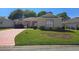 Charming single-story home featuring a well-manicured lawn and inviting curb appeal with pink driveway at 5008 Sawgrass Lake Cir, Leesburg, FL 34748