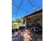Spacious screened-in patio with a brick floor, outdoor furniture, and beautiful views of the manicured lawn at 5008 Sawgrass Lake Cir, Leesburg, FL 34748