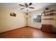 A minimalist bedroom with hardwood floors, ceiling fan, and a window providing natural light and a view at 5331 Magnolia Ridge Rd, Fruitland Park, FL 34731