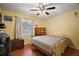 A bright bedroom featuring hardwood floors, large window, ceiling fan, and classic writing desk at 5331 Magnolia Ridge Rd, Fruitland Park, FL 34731