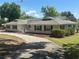 Charming single-story home with a long, curved driveway, manicured landscaping, and traditional architecture at 5331 Magnolia Ridge Rd, Fruitland Park, FL 34731