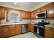 Bright kitchen featuring stainless steel appliances, wood cabinets, and durable tile flooring at 5331 Magnolia Ridge Rd, Fruitland Park, FL 34731