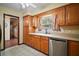 Bright kitchen with light wood cabinets, stainless steel dishwasher and view to adjacent rooms and backyard at 5331 Magnolia Ridge Rd, Fruitland Park, FL 34731