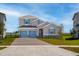 Charming two-story home featuring a two-car garage and nicely landscaped front yard with blue shutters at 5457 Marshelder St, Apopka, FL 32712