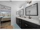 Well-lit bathroom featuring double sinks, dark cabinetry, and elegant fixtures at 5549 Millican Ave, The Villages, FL 32163