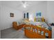 Bright bedroom with two twin beds, colorful linens, and light gray wood-look flooring at 5549 Millican Ave, The Villages, FL 32163