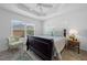 Comfortable bedroom showcasing plush bed, tray ceiling, and large window at 5549 Millican Ave, The Villages, FL 32163
